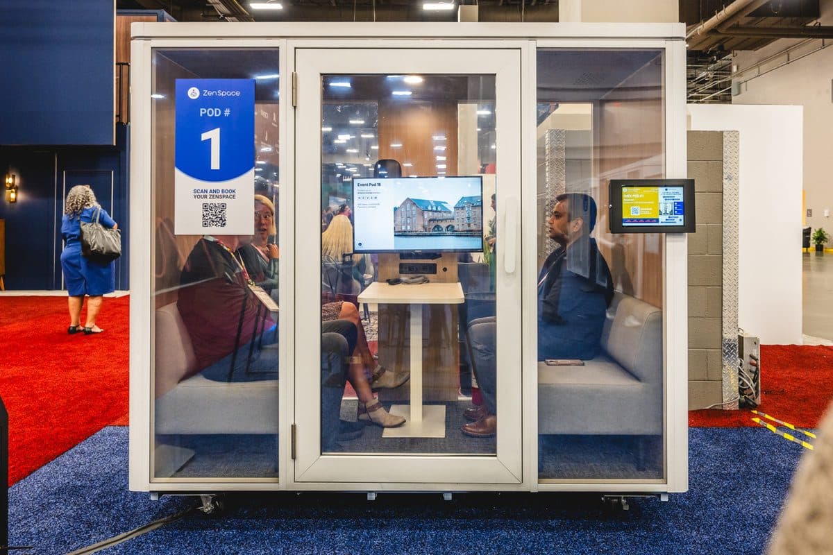 Attendee working inside a bookable pod on a show floor
