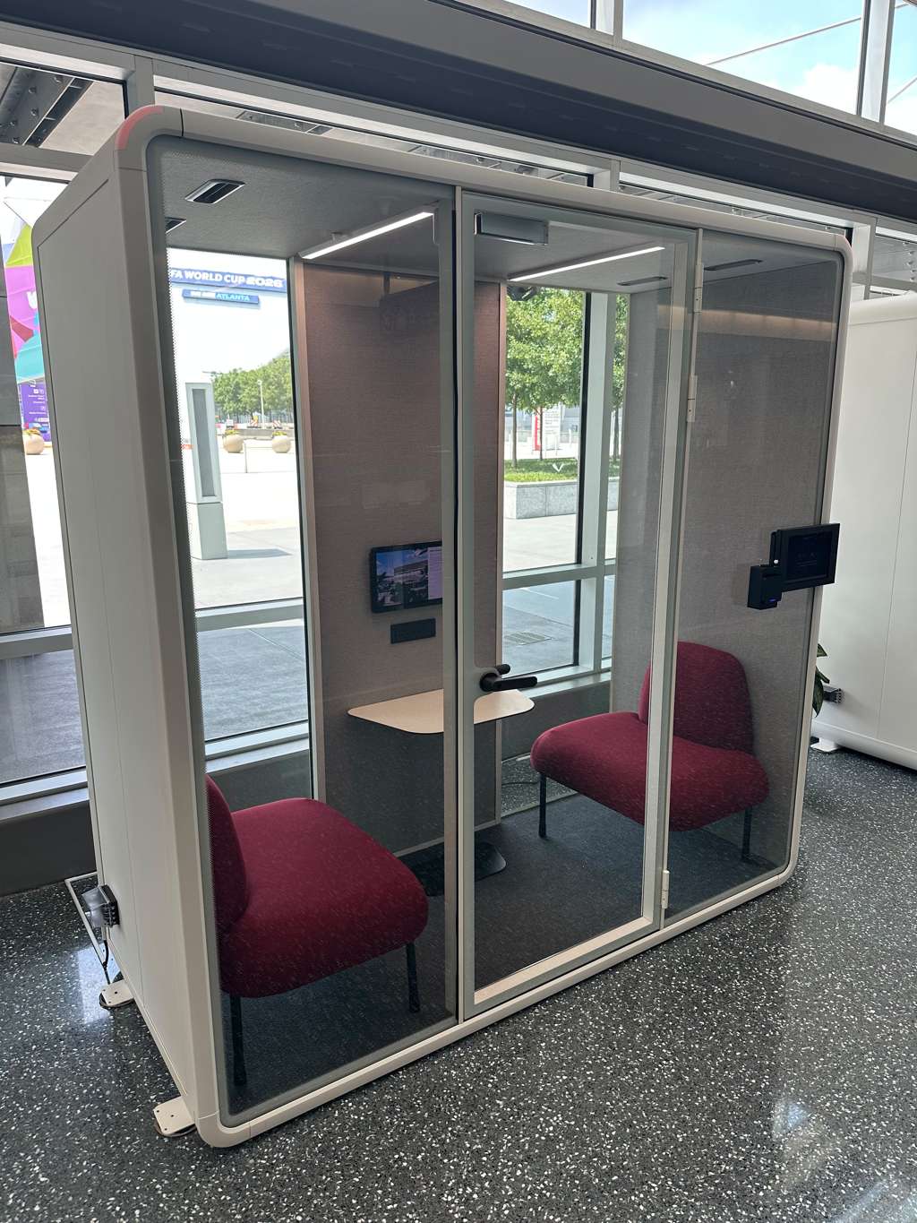 A ZenSpace glass meeting pod with lounge seating at the Georgia World Congress Center